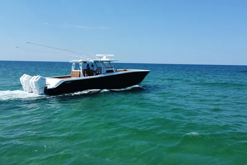  Yacht Photos Pics 2024 Invincible 46 Catamaran cruising on open sea under clear blue sky.
