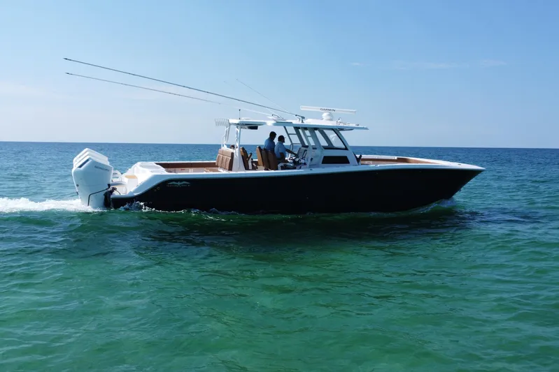  Yacht Photos Pics 2024 Invincible 46 Catamaran cruising on clear ocean waters.