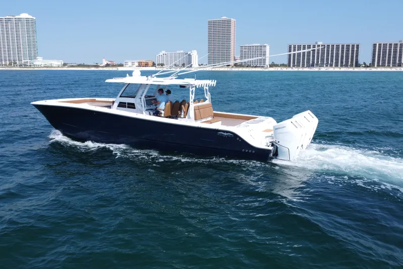  Yacht Photos Pics 2024 Invincible 46 Catamaran cruising on ocean near coastal cityscape.