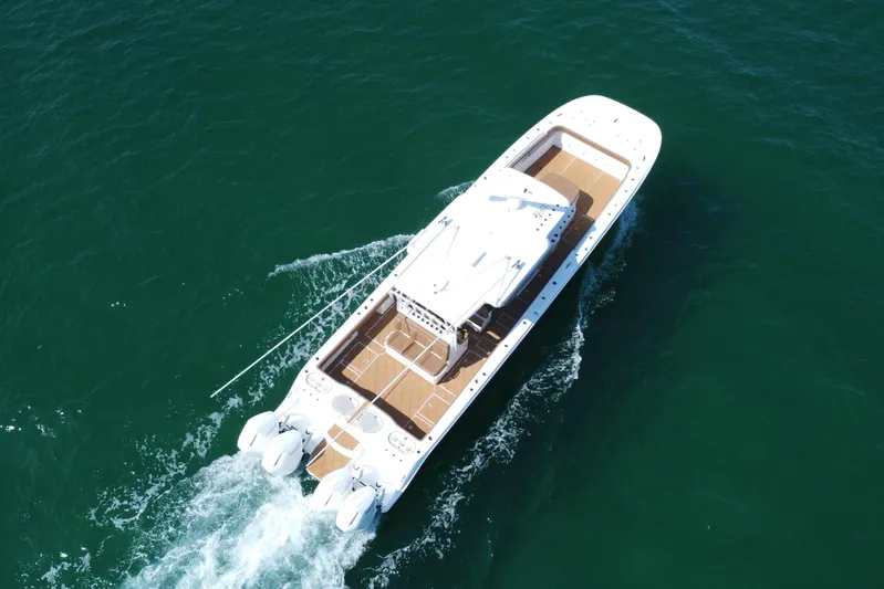  Yacht Photos Pics 2024 Invincible 46 Catamaran cruising on open water, aerial view.