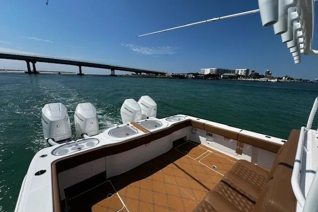  Yacht Photos Pics 2024 Invincible 46 Catamaran cruising on water with bridge in background.