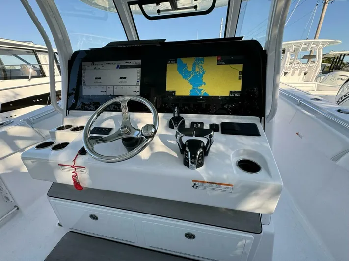 Yacht Photos Pics 2024 Sportsman 352 Open boat dashboard with navigation screens and steering wheel.