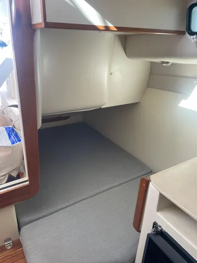 Five Belles Yacht Photos Pics 2001 Albin 28TE cabin interior with cushioned berth and wooden accents.