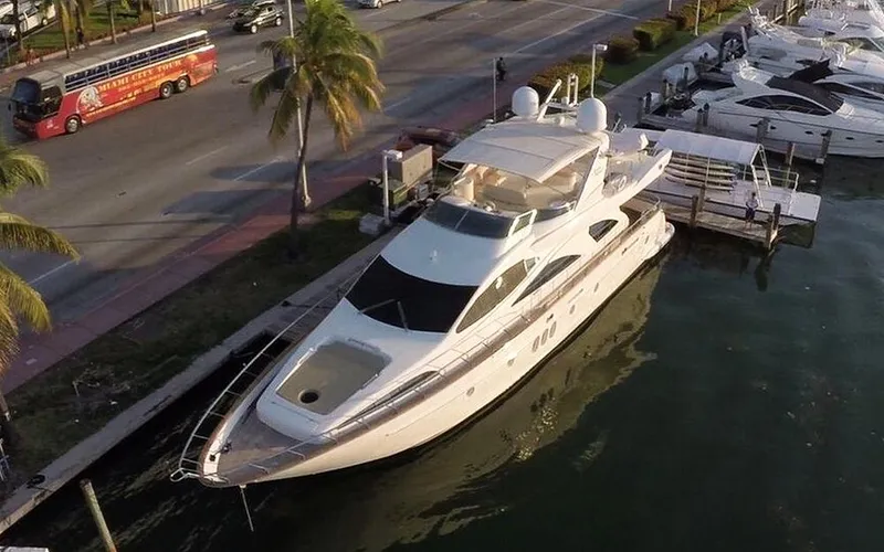 Dreamer Yacht Photos Pics Luxury 2005 Azimut 80 Carat yacht docked near palm-lined street.