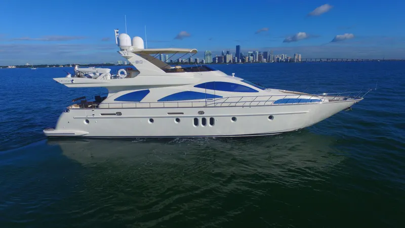 Dreamer Yacht Photos Pics Luxury 2005 Azimut 80 Carat yacht cruising on open water with city skyline backdrop.