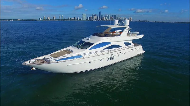 Dreamer Yacht Photos Pics Luxury 2005 Azimut 80 Carat yacht cruising near city skyline on a sunny day.