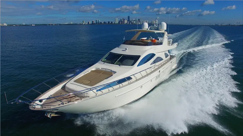 Dreamer Yacht Photos Pics Azimut 80 Carat 2005 yacht cruising on open water with city skyline in background.