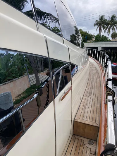 Dreamer Yacht Photos Pics 2005 Azimut 80 Carat yacht with sleek design and wooden deck, docked near palm trees.