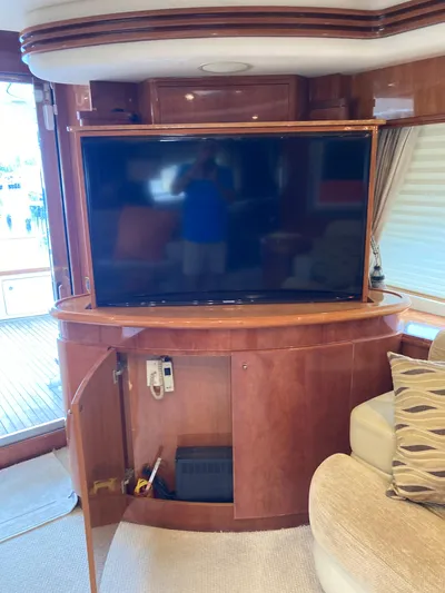 Dreamer Yacht Photos Pics Luxurious interior of 2005 Azimut 80 Carat yacht with large TV and wooden cabinetry.