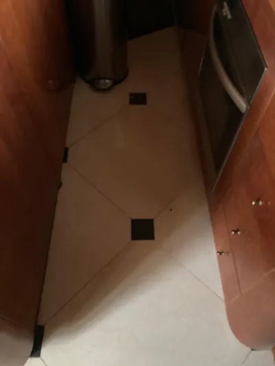 Dreamer Yacht Photos Pics Narrow kitchen space on 2005 Azimut 80 Carat yacht with wood cabinets and tiled floor.