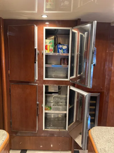 Dreamer Yacht Photos Pics Wooden kitchen cabinets with open doors on a 2005 Azimut 80 Carat yacht.