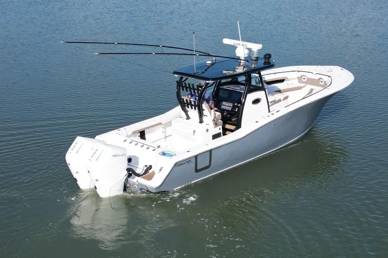  Yacht Photos Pics 2025 Tidewater 320 CC Adventure boat on calm water, featuring dual Mercury engines.