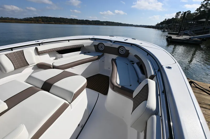  Yacht Photos Pics 2025 Tidewater 320 CC Adventure boat interior with luxurious seating on a serene lake.