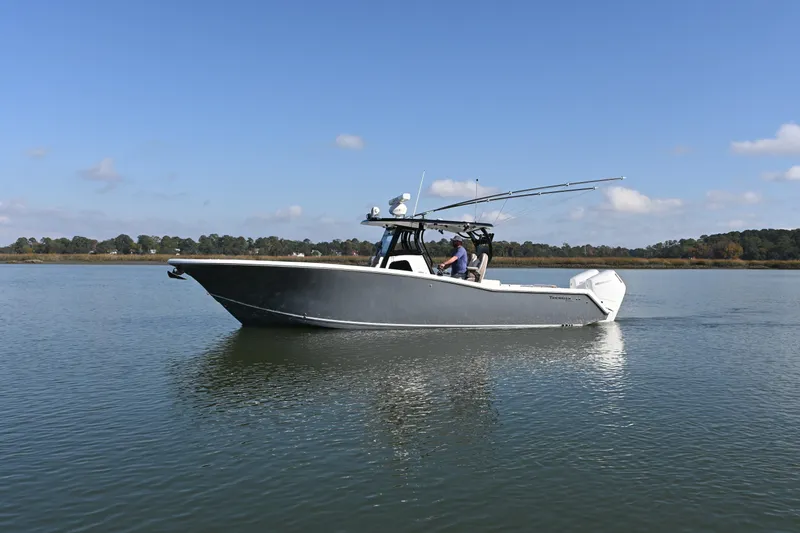 Yacht Photos Pics 2025 Tidewater 320 CC Adventure boat cruising on calm water under clear skies.