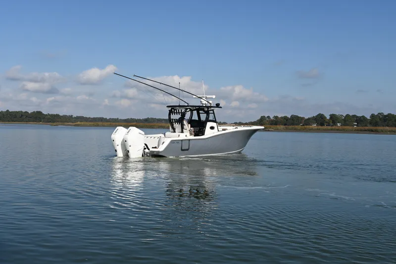  Yacht Photos Pics 2025 Tidewater 320 CC Adventure boat cruising on calm waters under a clear sky.