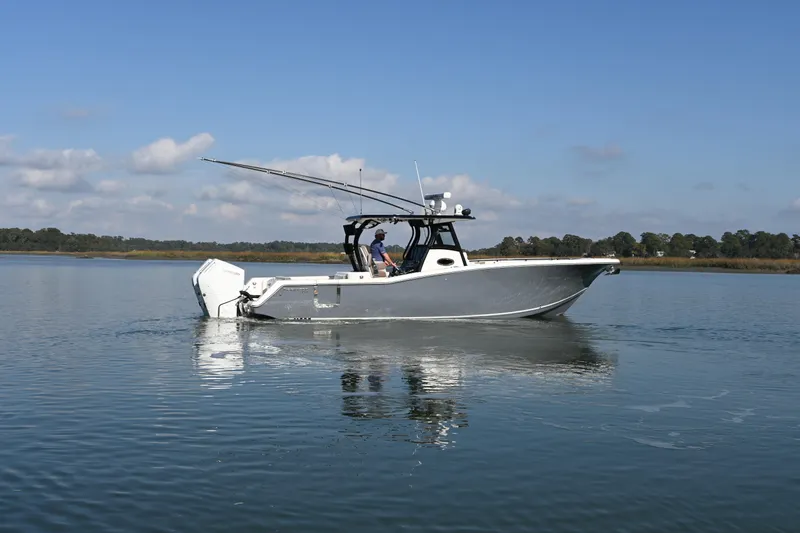  Yacht Photos Pics 2025 Tidewater 320 CC Adventure boat on calm water under blue sky.