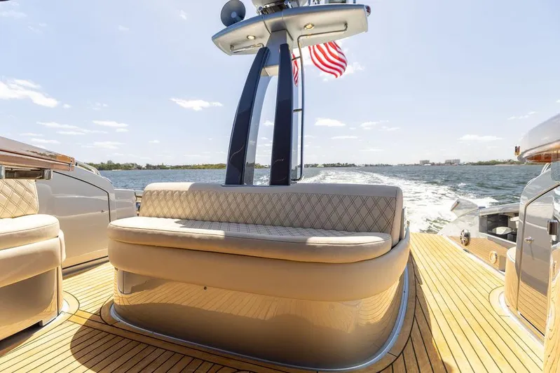 Andiamo Yacht Photos Pics 2014 Riva 52 LE yacht with elegant seating and American flag on open water.