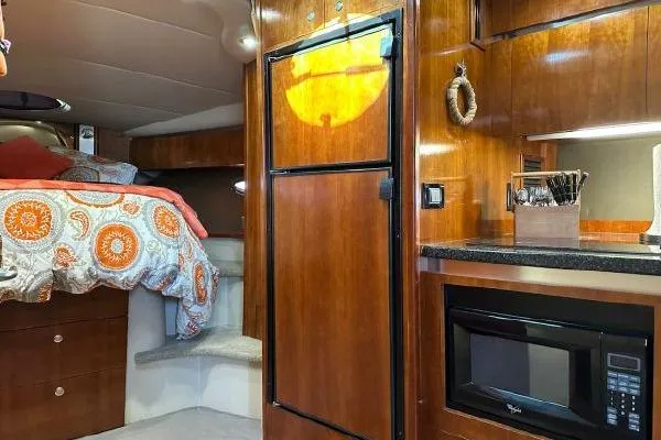  Yacht Photos Pics Luxurious 2005 Cruisers 420 yacht interior with cozy bed, kitchenette, and wooden cabinetry.