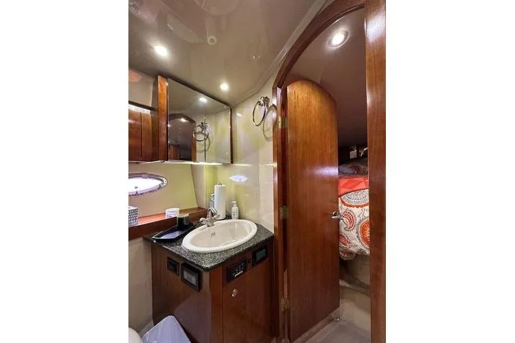  Yacht Photos Pics Luxurious 2005 Cruisers 420 yacht bathroom with sink, mirror, and wooden cabinetry.