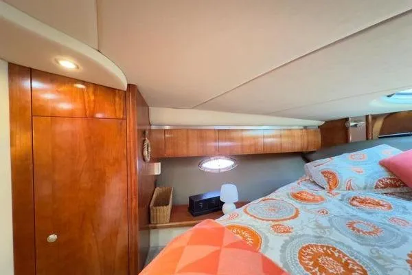  Yacht Photos Pics 2005 Cruisers 420 yacht cabin with wood paneling and patterned bedding.