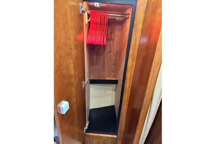  Yacht Photos Pics Wooden closet with red hangers inside a 2005 Cruisers 420 boat.
