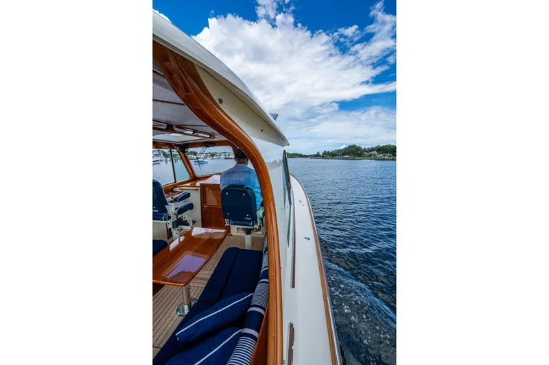 Ruckus Yacht Photos Pics 2017 Hinckley Picnic Boat 37 MKIII cruising on a scenic waterway under a blue sky.