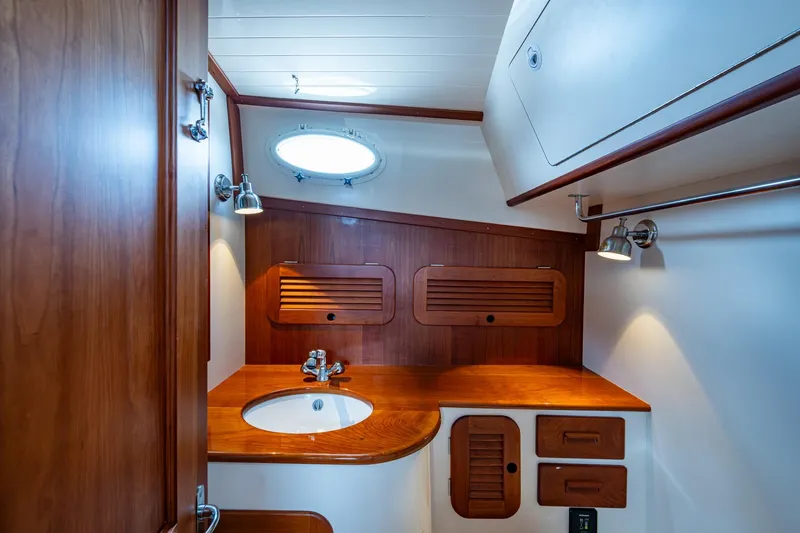 Ruckus Yacht Photos Pics Luxurious wooden interior of 2017 Hinckley Picnic Boat 37 MKIII bathroom with sink and lighting.