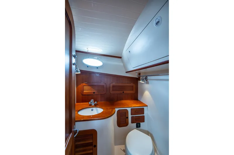 Ruckus Yacht Photos Pics Hinckley Picnic Boat 37 MKIII 2017 bathroom with wooden cabinetry and modern fixtures.