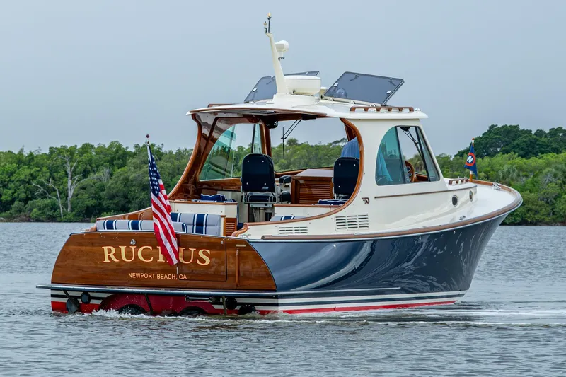 Ruckus Yacht Photos Pics 2017 Hinckley Picnic Boat 37 MKIII cruising on water, rear view with American flag.