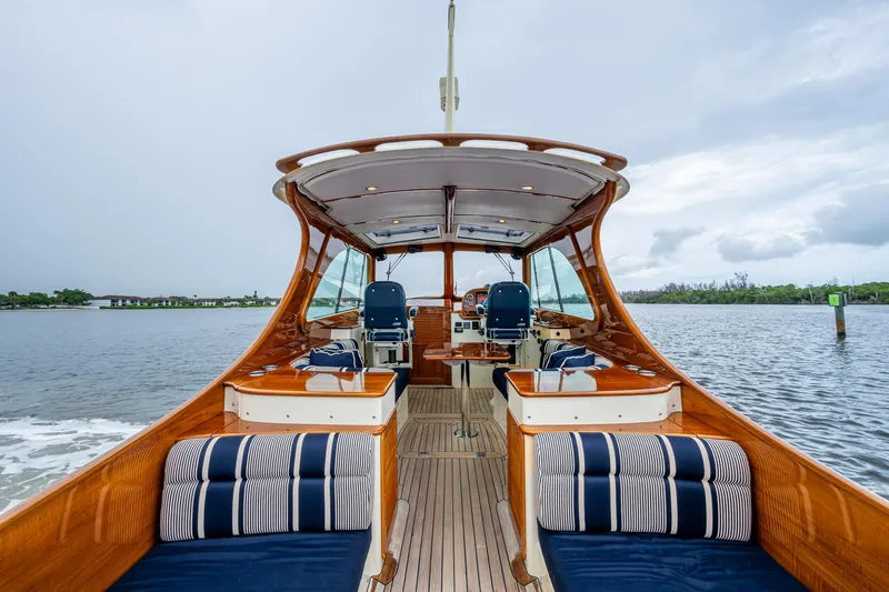 Ruckus Yacht Photos Pics 2017 Hinckley Picnic Boat 37 MKIII on water, elegant interior, wooden finish, striped cushions.