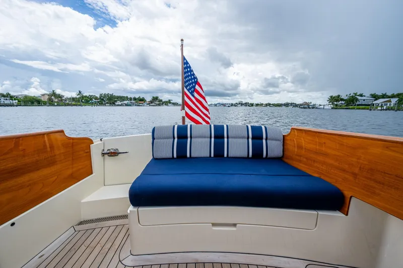 Ruckus Yacht Photos Pics 2017 Hinckley Picnic Boat 37 MKIII with American flag, blue seating, and scenic water view.