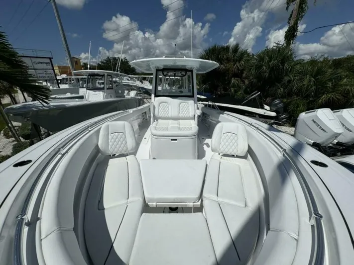  Yacht Photos Pics 2025 Sportsman 322 Open boat with white seating, docked under a blue sky.