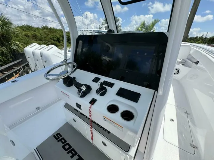  Yacht Photos Pics 2025 Sportsman 322 Open boat console with steering wheel and controls under blue sky.