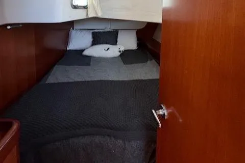 Simone Yacht Photos Pics Cozy cabin interior of 2007 Beneteau 490 yacht with bed and wooden finish.