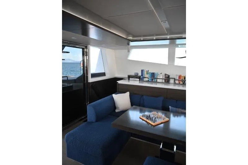  Yacht Photos Pics Luxurious interior of 2015 Sunreef 74 yacht with blue seating and chessboard.