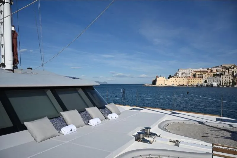  Yacht Photos Pics Luxurious Sunreef 74 yacht deck with cushions, overlooking scenic coastal view, 2015 model.