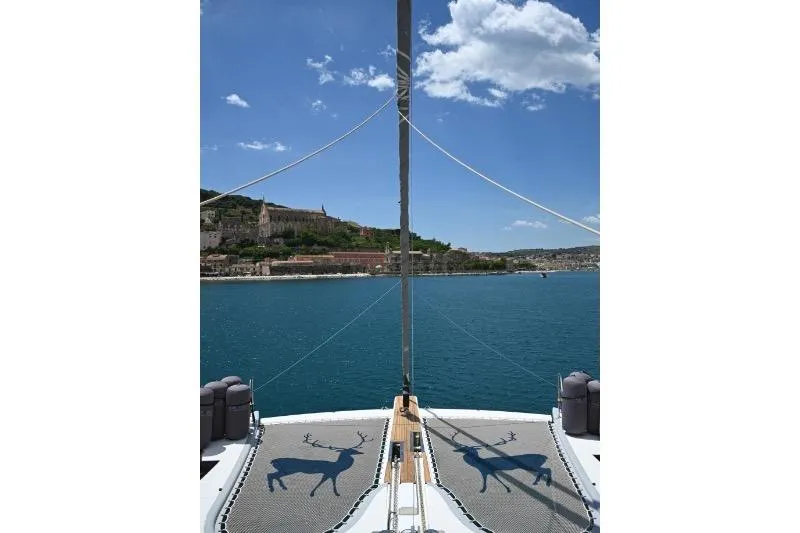  Yacht Photos Pics Catamaran Sunreef 74 (2015) on serene blue waters with coastal view.