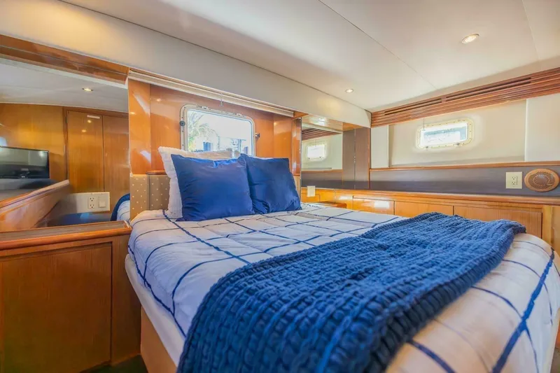 Hanalei Yacht Photos Pics Luxurious bedroom interior of 1999 Hatteras 52 Sport Deck Motor Yacht with blue bedding.