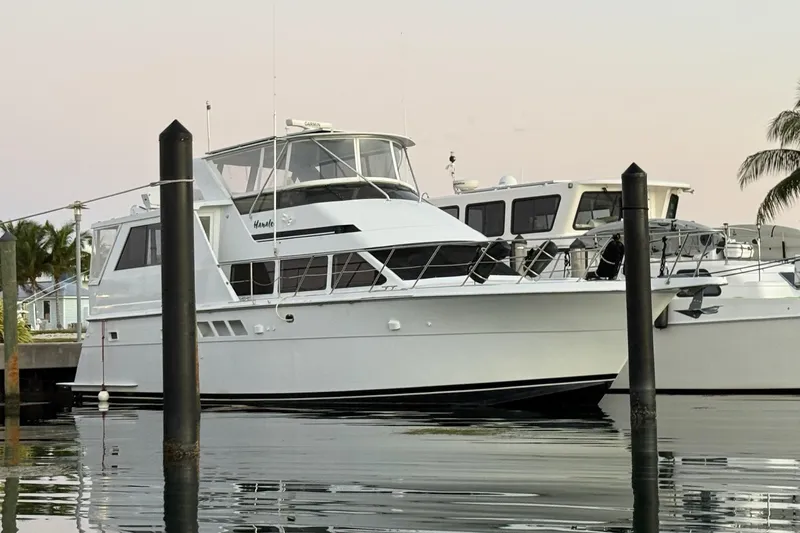 Hanalei Yacht Photos Pics 1999 Hatteras 52 Sport Deck Motor Yacht docked at marina, calm water reflection.