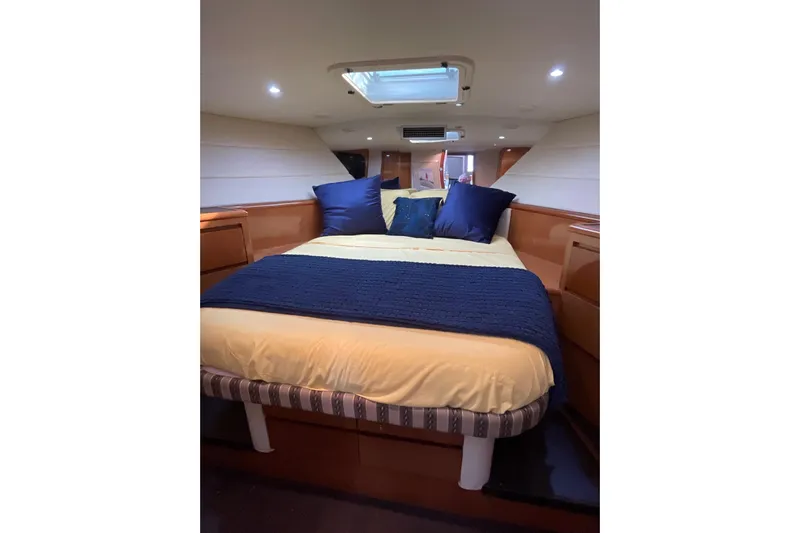 Hanalei Yacht Photos Pics Cozy bedroom in 1999 Hatteras 52 Sport Deck Motor Yacht with skylight and blue accents.