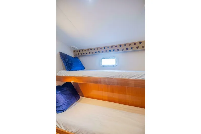 Hanalei Yacht Photos Pics 1999 Hatteras 52 Sport Deck Motor Yacht cabin with bunk beds and blue pillows.