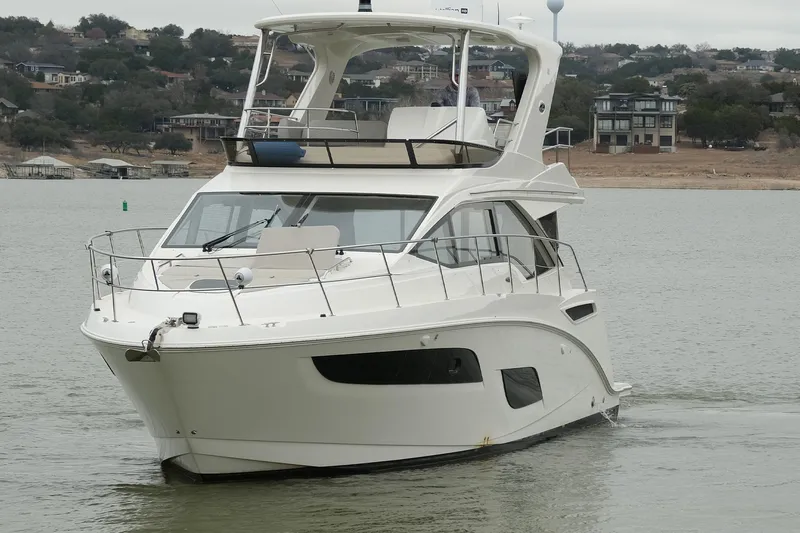 Smooth Yacht Photos Pics 2018 Sea Ray Fly 460 yacht cruising on a calm lake with scenic background.