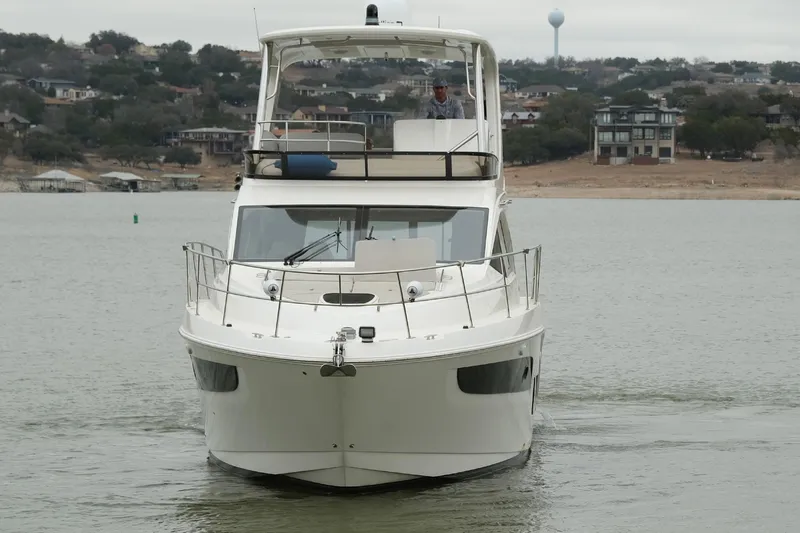 Smooth Yacht Photos Pics 2018 Sea Ray Fly 460 yacht cruising on a calm lake with scenic shoreline.