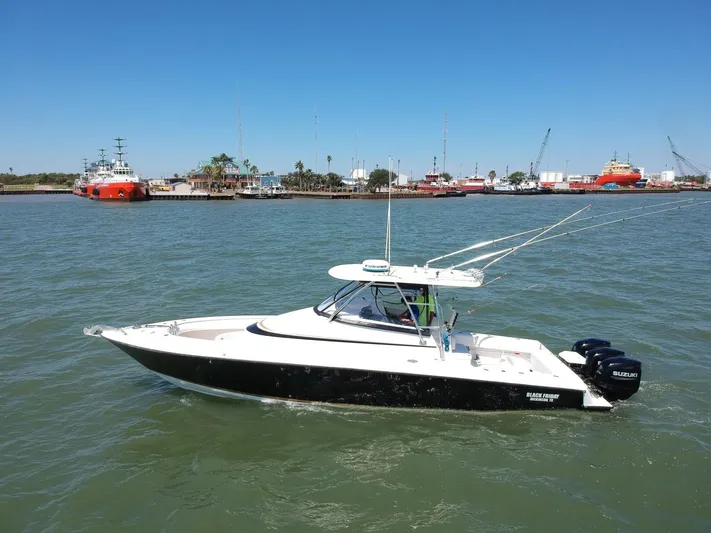 Black Friday Yacht Photos Pics 2008 Contender 36 Fish Around boat on water with marina background.