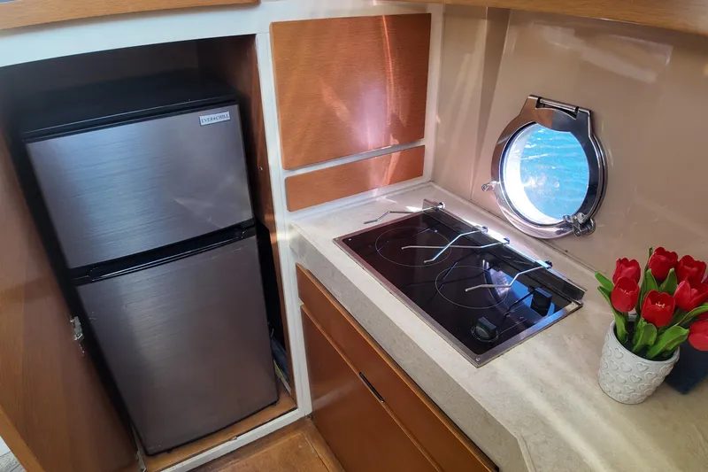  Yacht Photos Pics Azimut 40 FLY 2012 yacht kitchen with stove, fridge, and porthole.