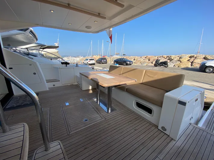 Coco Yacht Photos Pics 2012 Fairline Squadron 65 yacht deck with seating and table, docked at marina.