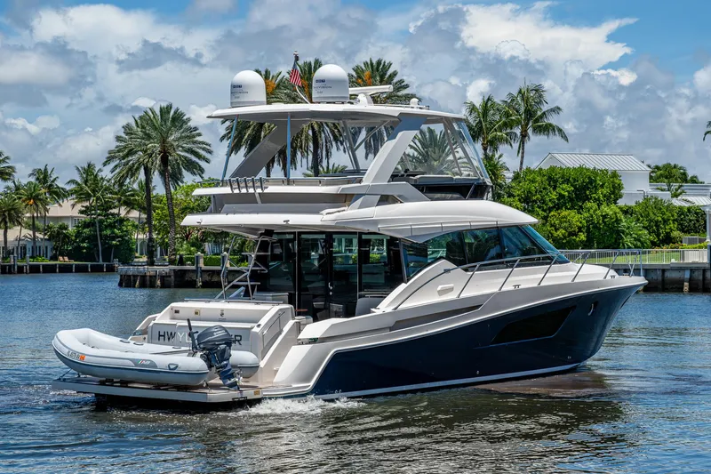 Hwyl Fawr Yacht Photos Pics 2018 Tiara Yachts F53 Flybridge cruising on a sunny day with palm trees in the background.