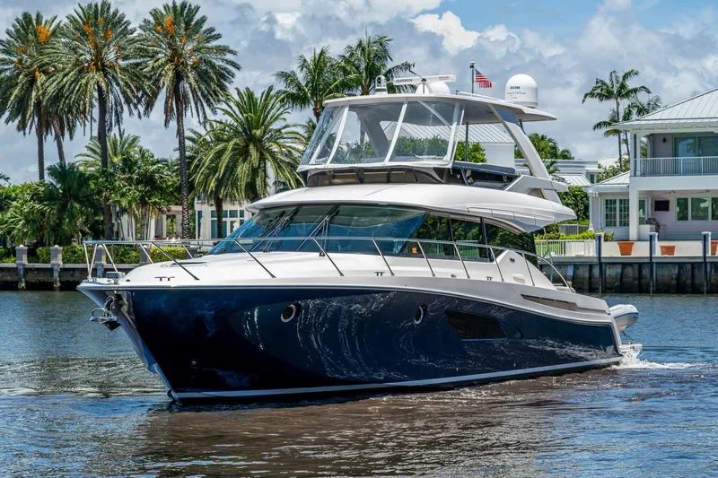 Hwyl Fawr Yacht Photos Pics 2018 Tiara Yachts F53 Flybridge cruising on a sunny day with palm trees in the background.