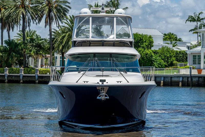 Hwyl Fawr Yacht Photos Pics 2018 Tiara Yachts F53 Flybridge on water, surrounded by palm trees and luxury homes.