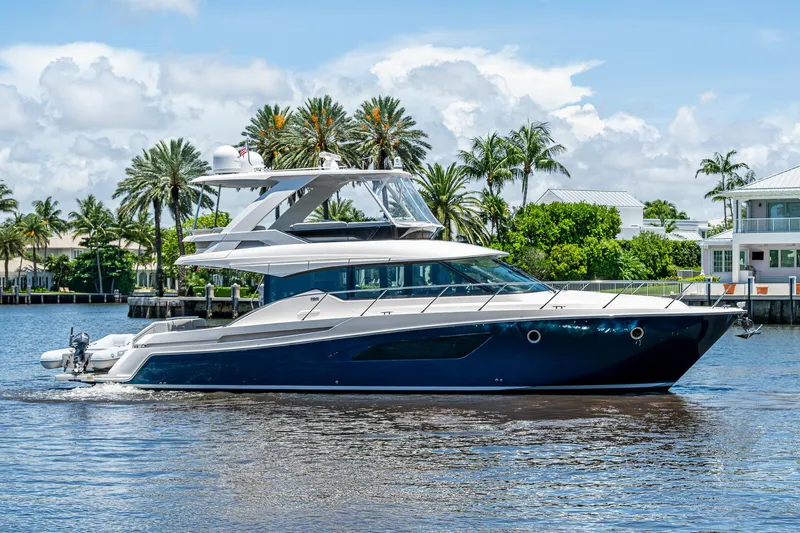 Hwyl Fawr Yacht Photos Pics 2018 Tiara Yachts F53 Flybridge cruising on a sunny day with palm trees in the background.